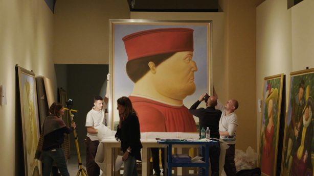 A photo of a painting by Botero with photographers around the painting taking photos.