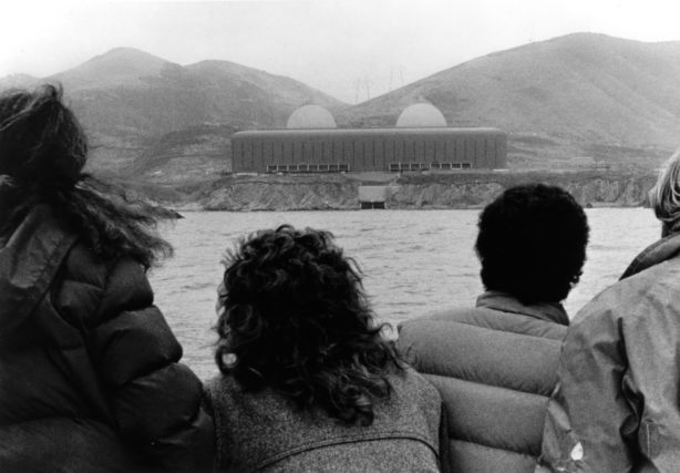 Activists look upon a nuclear power plant