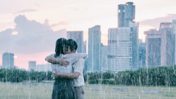 A man and a woman embrace in the middle of a monsoon. 