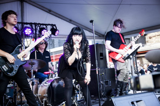 Lydia Lunch singing onstage with her band at a concert.