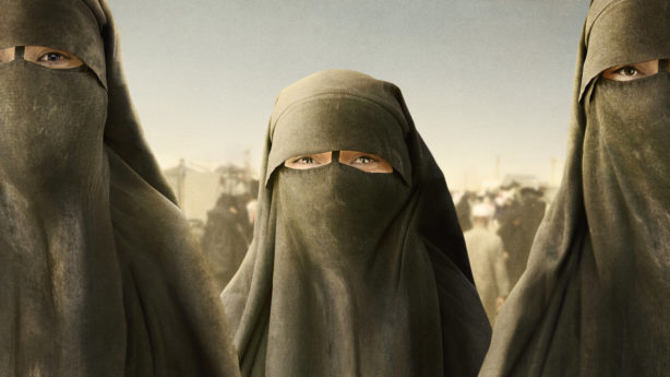 Three women in Niqab's looking out front beyond the camera.