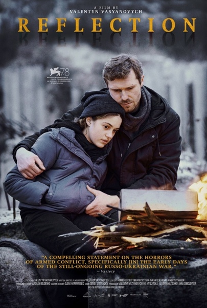 A daughter being held by her father in front of a fire out of doors